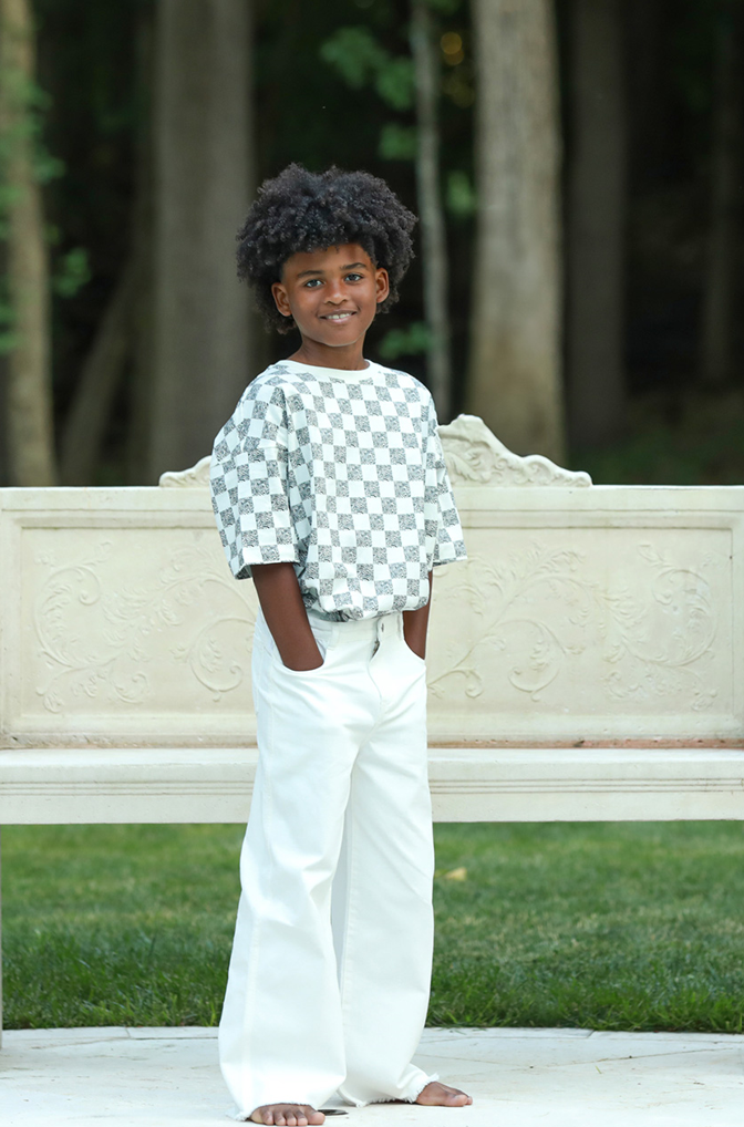 Off White/Black Animal Checker - Front view model in relaxed fit cotton kids tee with checker print — soft, sustainable, and eco-friendly